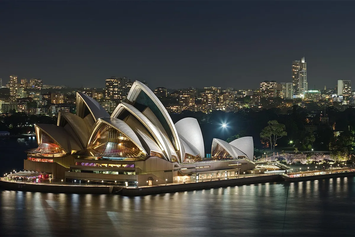 Sydney Opera House shells illuminated beside the harbour